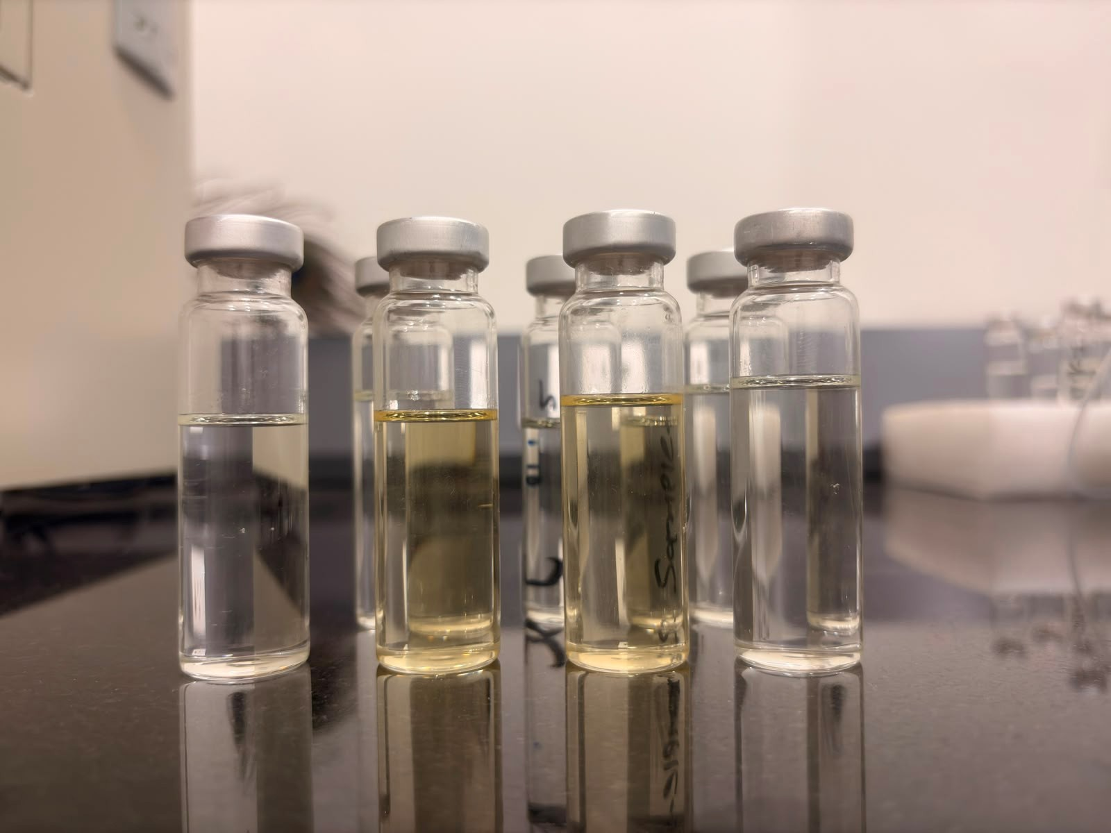 Transformer oil samples in glass vials showing differences in colour and clarity
